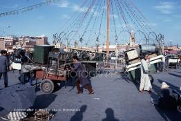 Image du Maroc Professionnelle de  Arrivée des restaurateurs au centre de la médina. Au coucher du soleil la place se métamorphose en un imense restaurants où touristes et marocains dinent sur la mythique Place Jemaa El Fana de Marrakech, Jeudi 19 Mai 1988.. (Photo / Abdeljalil Bounhar)

 